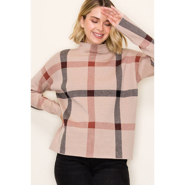 checkered jaquared sweater the base color is tan with black and red plaid like stripes throughout and a mock turtle neck