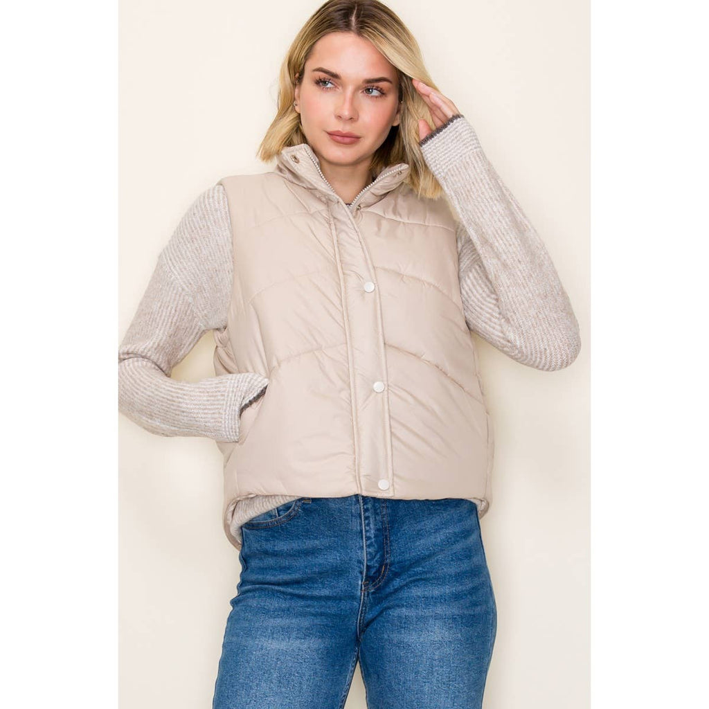 very light tan color puffer vest with side pockets and both zipper and button front
