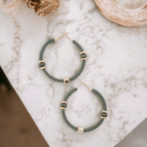 zephyr corded hoop sage green earrings with evenly spaced golden beads throughout.