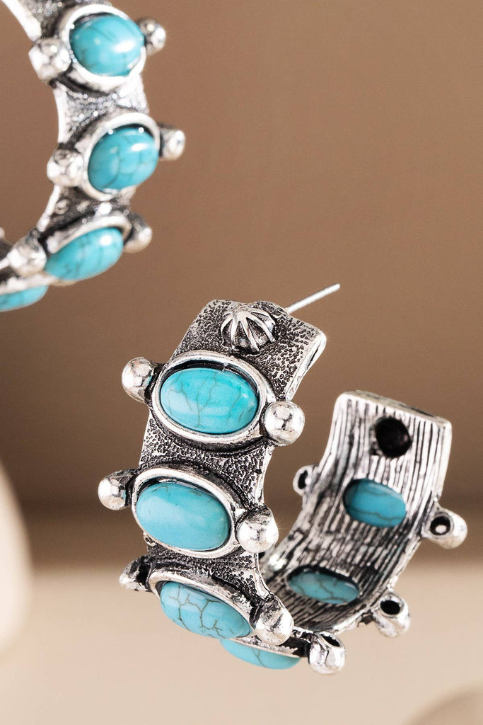 Chunky half hoops set with oval turquoise style cabochons and oxidized rope detailing for a bold Western look.