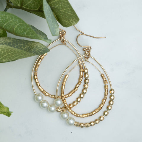 double layered hoop earrings with textured beading in gold and pearl white