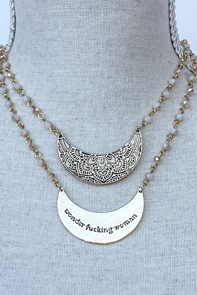 Single strand short chain link necklace with glass beads throughout the chain. Features a crescent shaped pendant with beautiful engraving on the front! Pendant features a fun sassy saying engraved on the back.